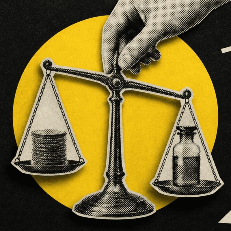 A hand steadies a balance scale weighing coins against a medicine bottle, on black.