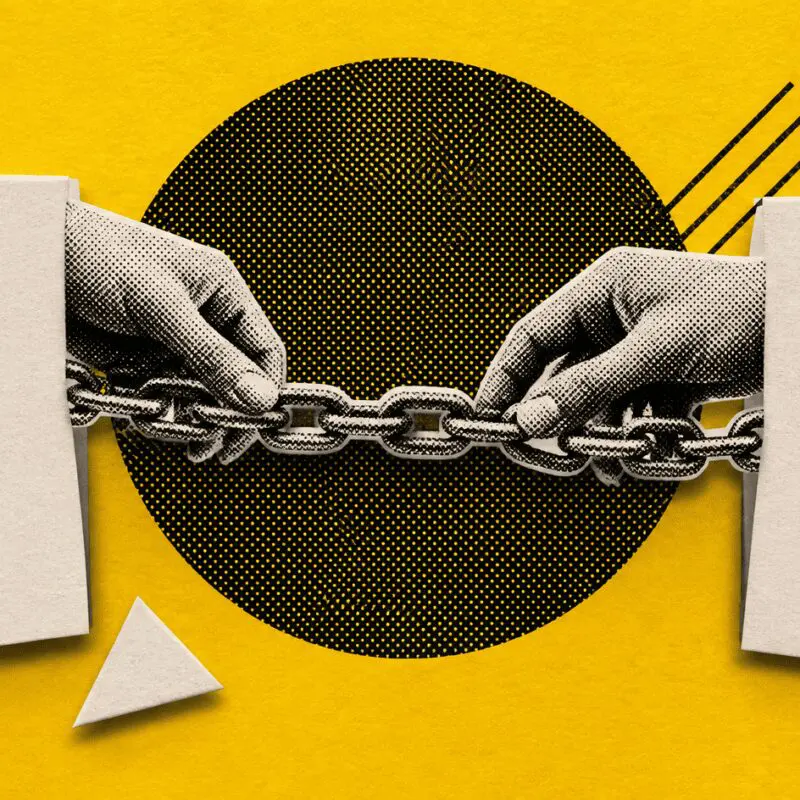 Two hands join lengths of chain to bridge two paper cards, on yellow.